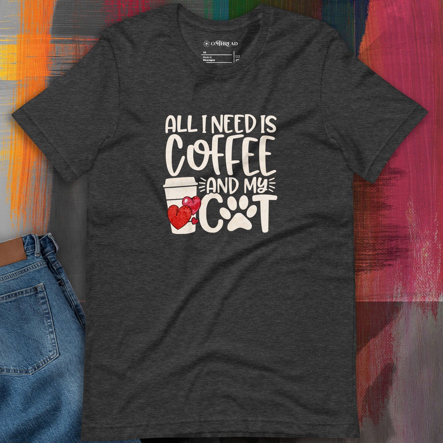 OMTHREAD dark gray t-shirt featuring the phrase "All I Need is Coffee and My Cat" in bold white lettering, accompanied by a heart-decorated coffee cup and a paw print design.