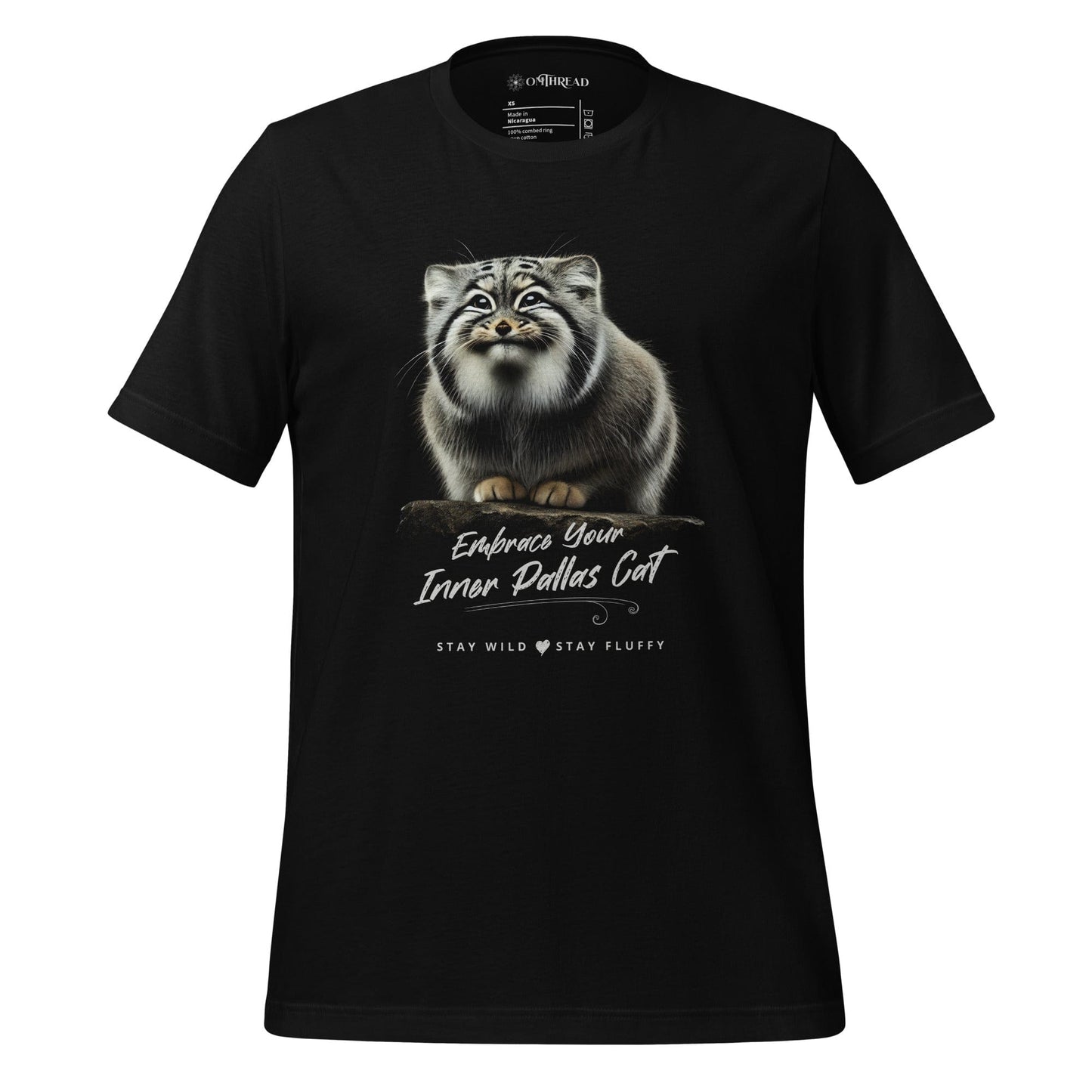 OMThread black t-shirt featuring a detailed black-and-white illustration of a Pallas cat standing on a rock. The cat has thick fur and piercing eyes. Below the image, "Embrace Your Inner Pallas Cat" is written in elegant white script, followed by "Stay Wild Stay Fluffy" in a modern font
