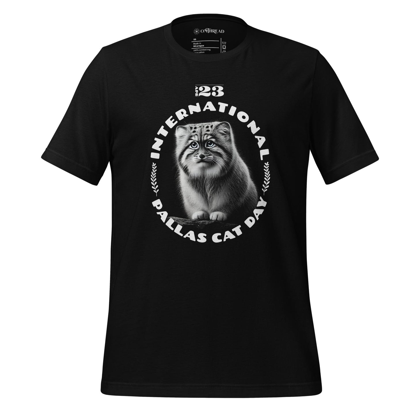 OMThread black t-shirt featuring a detailed black-and-white illustration of a Pallas cat inside a circular design. The words "International Pallas Cat Day" arch around the cat, with "April 23" positioned above.