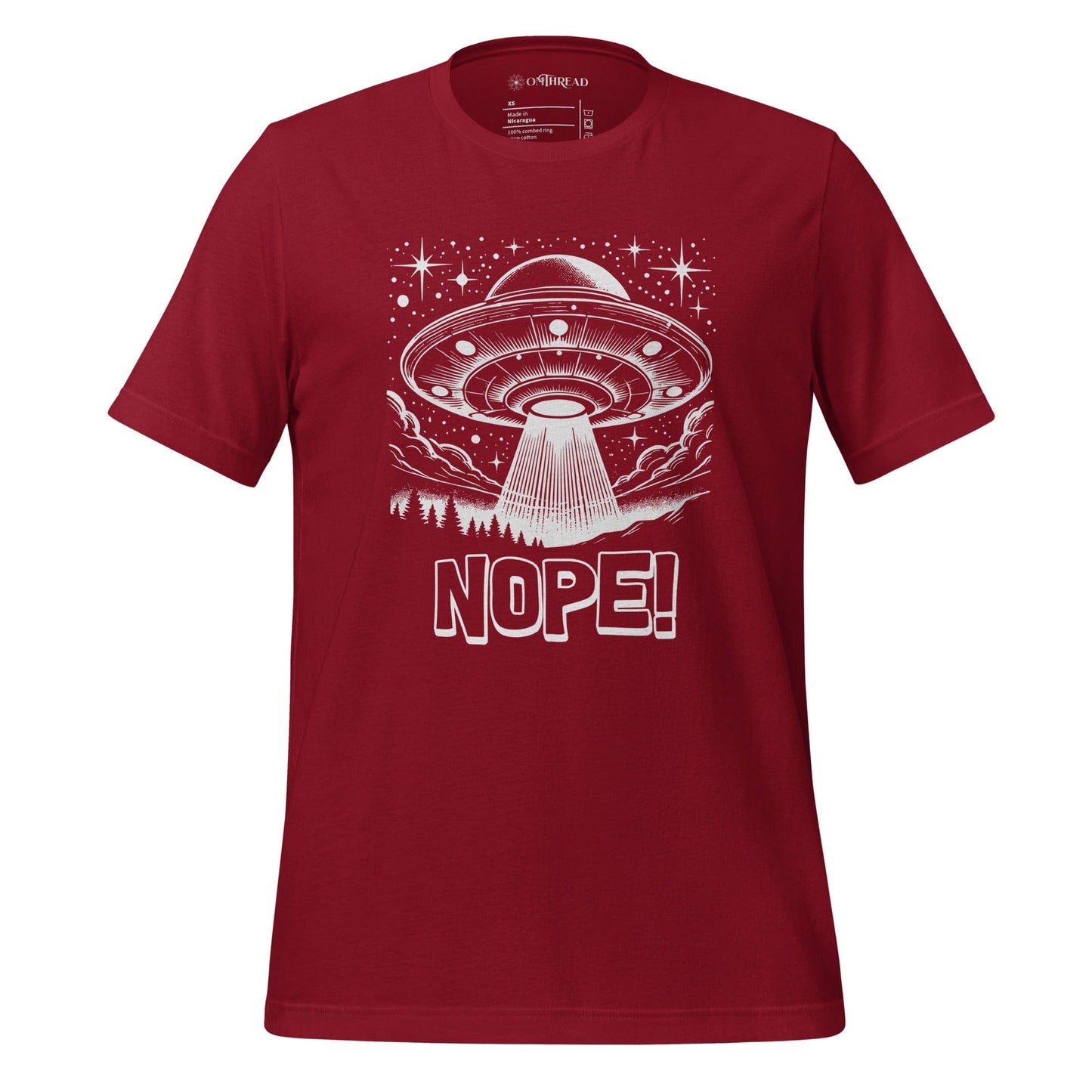 Crimson red t-shirt featuring a retro-style illustration of a UFO beaming light down onto a forest, surrounded by stars and clouds, with the bold text, NOPE! emphasizing humor and alien themes