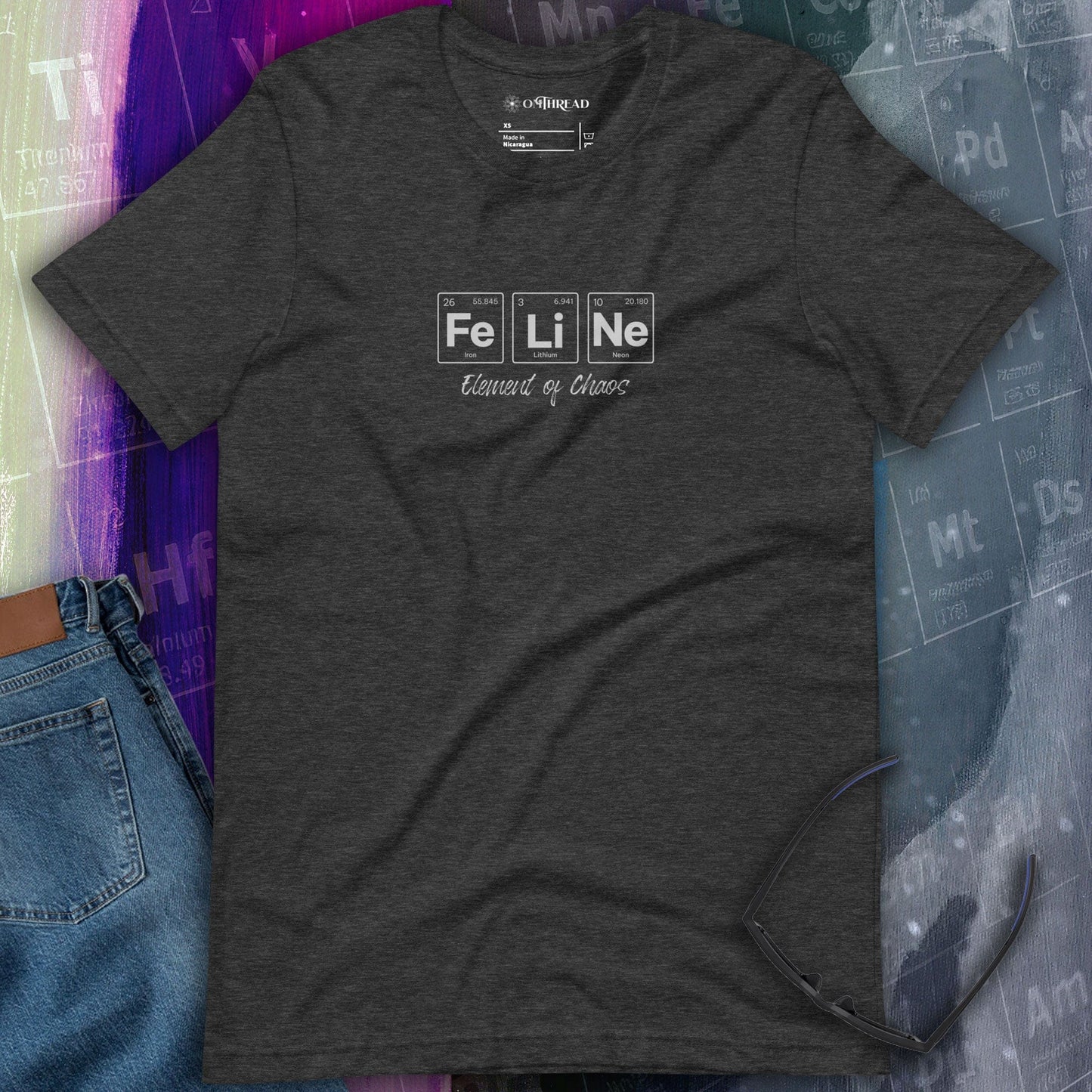 OMThread FeLiNe Element of Chaos dark gray t-shirt featuring the word "FeLiNe" spelled using periodic table elements Iron (Fe), Lithium (Li), and Neon (Ne), with "Element of Chaos" written below in cursive font.