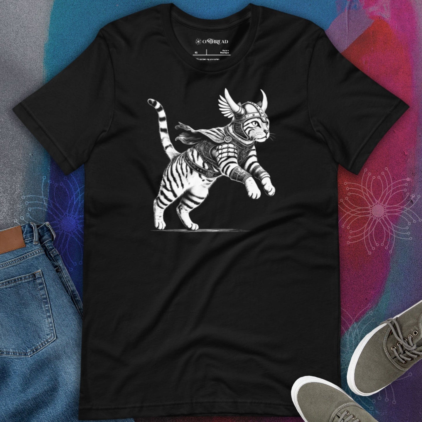 OMThread black t-shirt featuring a detailed illustration of a Viking cat in armor with a horned helmet, flowing cape, and feathered wings. The feline warrior is in an action-ready pose with intricate linework.