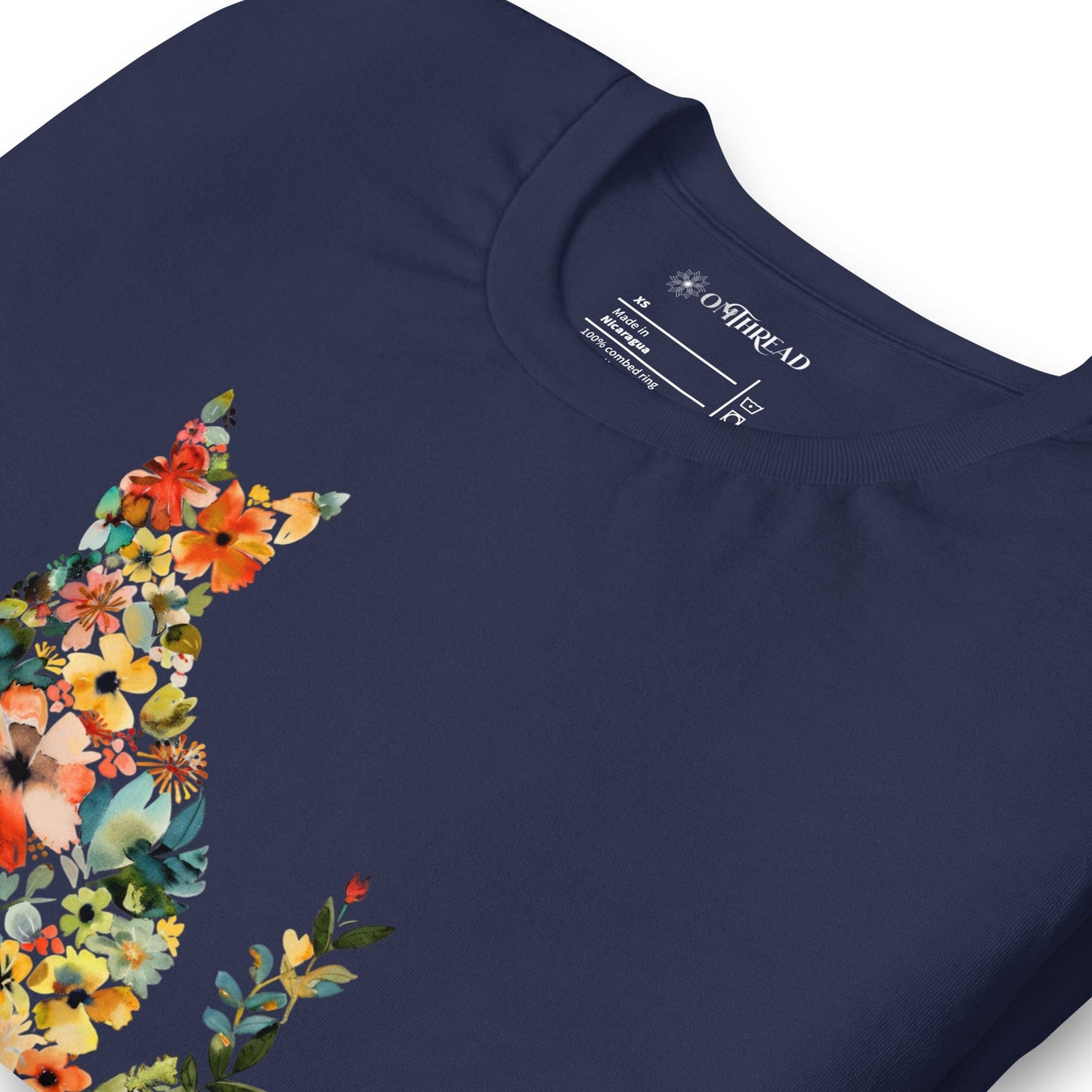 Navy blue t-shirt featuring a floral cat silhouette made of blooming flowers in vibrant colors. Below, the text 'Flower Child' is written in artistic script.