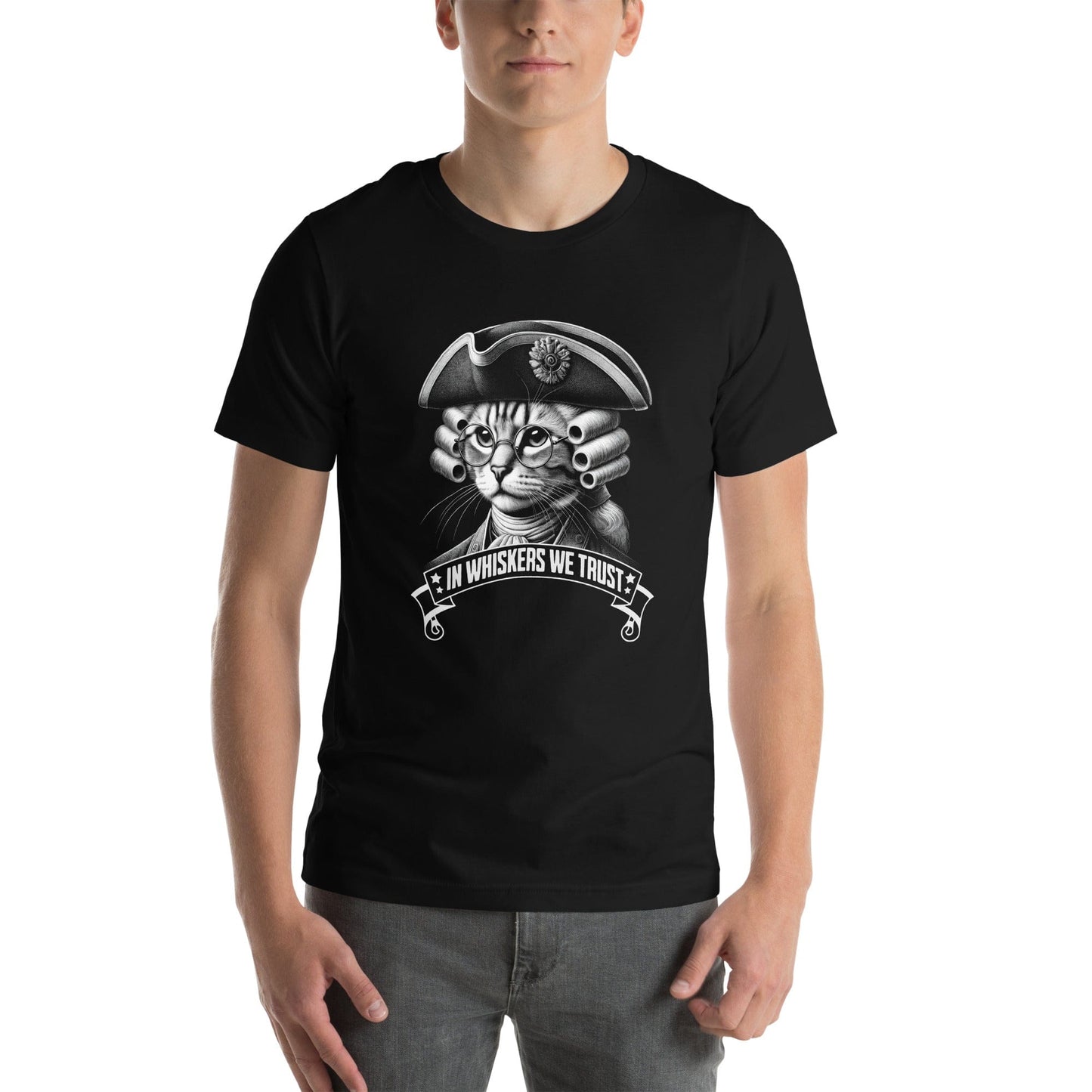 Man wearing black t-shirt featuring a distinguished cat dressed in revolutionary attire, complete with a tricorn hat, glasses, and powdered wig. The design includes the phrase, In Whiskers We Trust displayed on a decorative banner beneath the cat.
