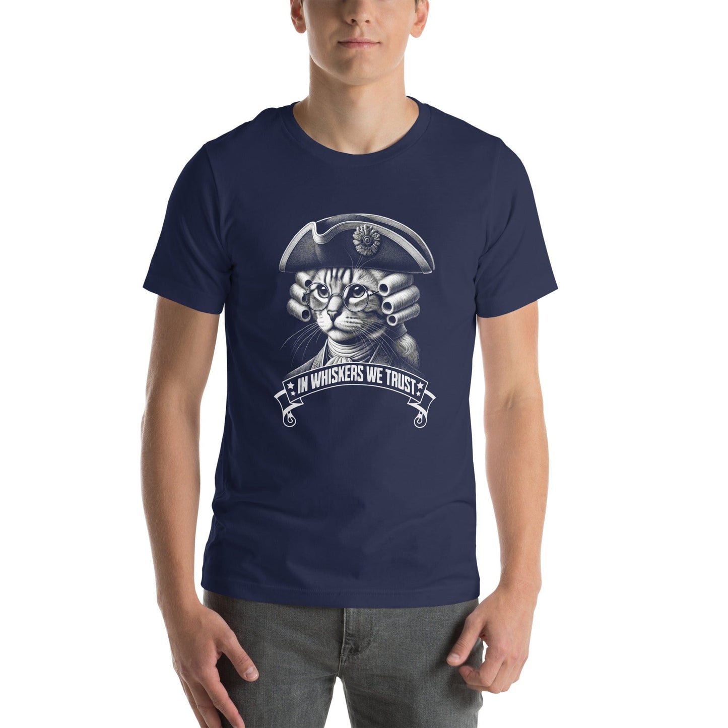 Man wearing navy blue t-shirt featuring a distinguished cat dressed in revolutionary attire, complete with a tricorn hat, glasses, and powdered wig. The design includes the phrase, In Whiskers We Trust displayed on a decorative banner beneath the cat.