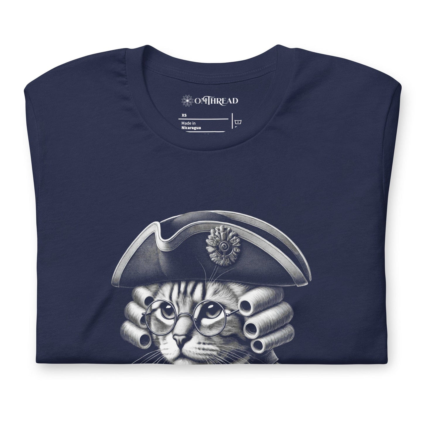 Navy blue t-shirt featuring a distinguished cat dressed in revolutionary attire, complete with a tricorn hat, glasses, and powdered wig. The design includes the phrase, In Whiskers We Trust displayed on a decorative banner beneath the cat.