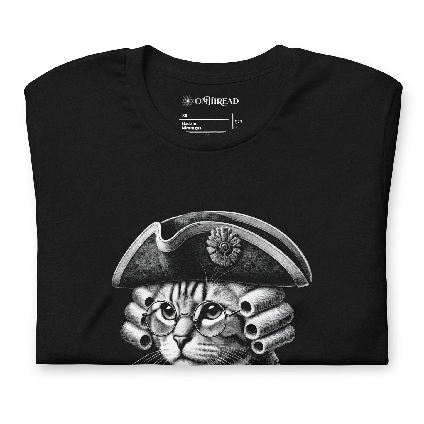 Black t-shirt featuring a distinguished cat dressed in revolutionary attire, complete with a tricorn hat, glasses, and powdered wig. The design includes the phrase, In Whiskers We Trust displayed on a decorative banner beneath the cat.