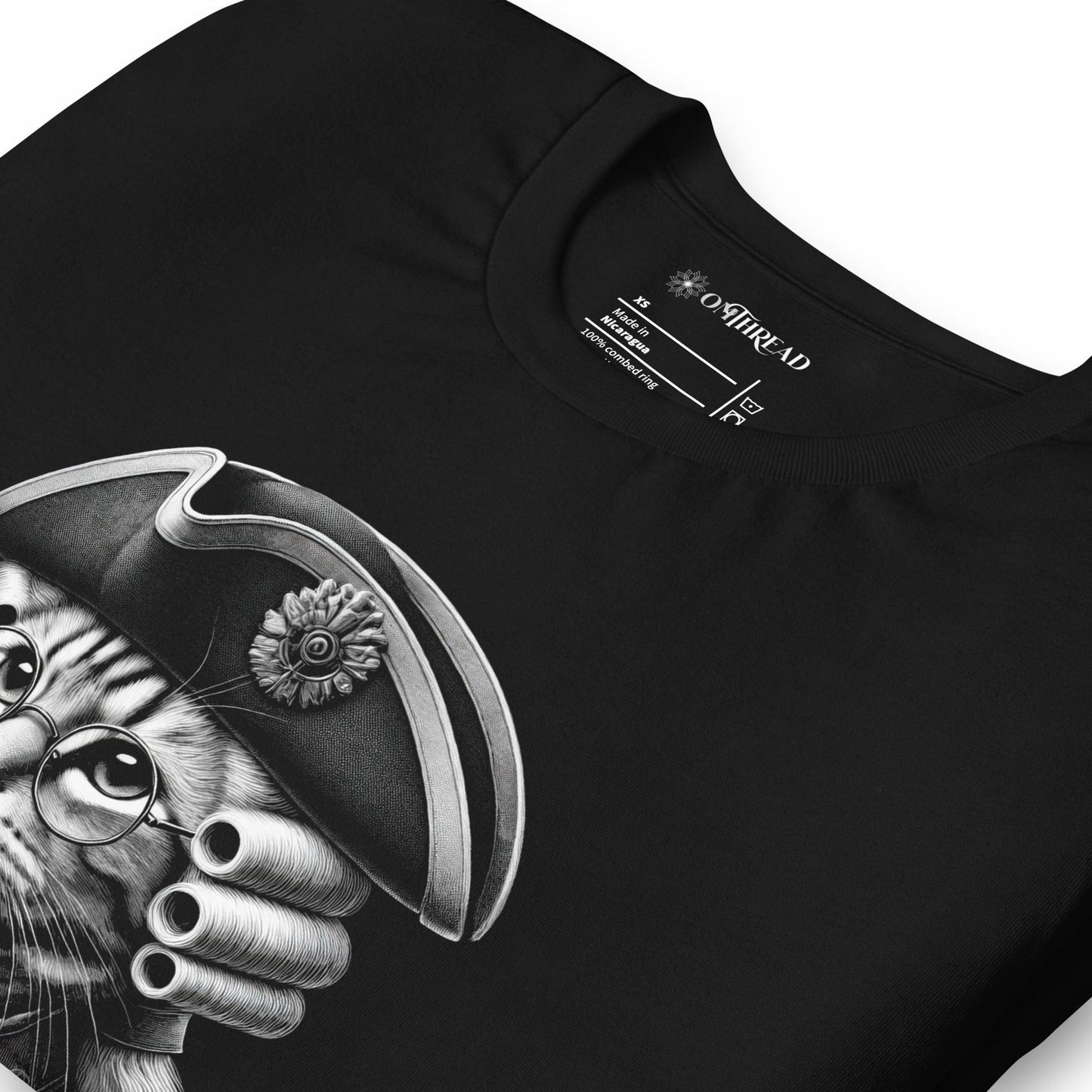 Black t-shirt featuring a distinguished cat dressed in revolutionary attire, complete with a tricorn hat, glasses, and powdered wig. The design includes the phrase, In Whiskers We Trust displayed on a decorative banner beneath the cat.