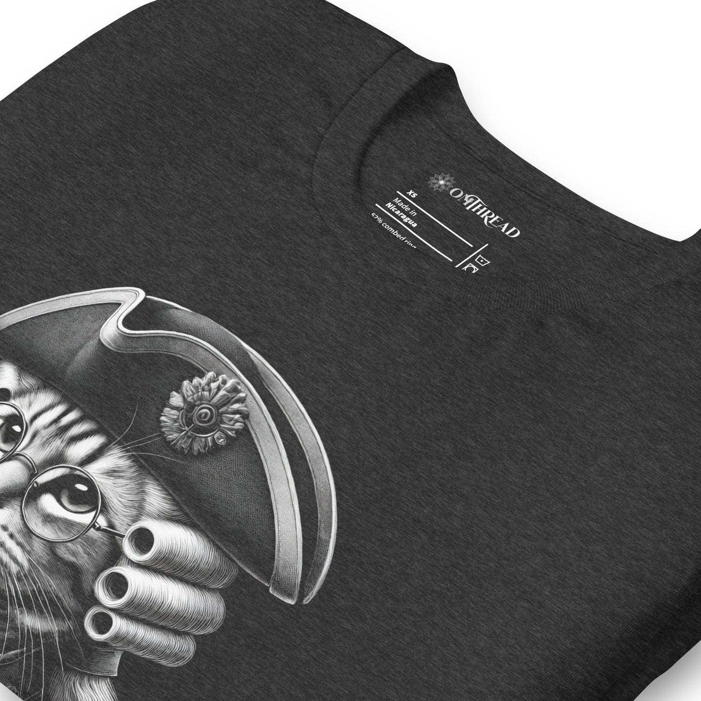 Dark gray t-shirt featuring a distinguished cat dressed in revolutionary attire, complete with a tricorn hat, glasses, and powdered wig. The design includes the phrase, In Whiskers We Trust displayed on a decorative banner beneath the cat.
