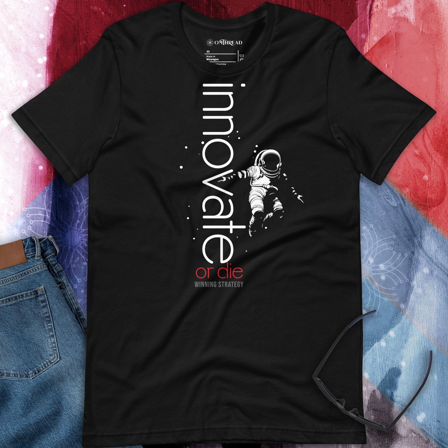 OMTHREAD black t-shirt featuring an astronaut floating in space with the words "Innovate or Die" in vertical typography, accented with red text.