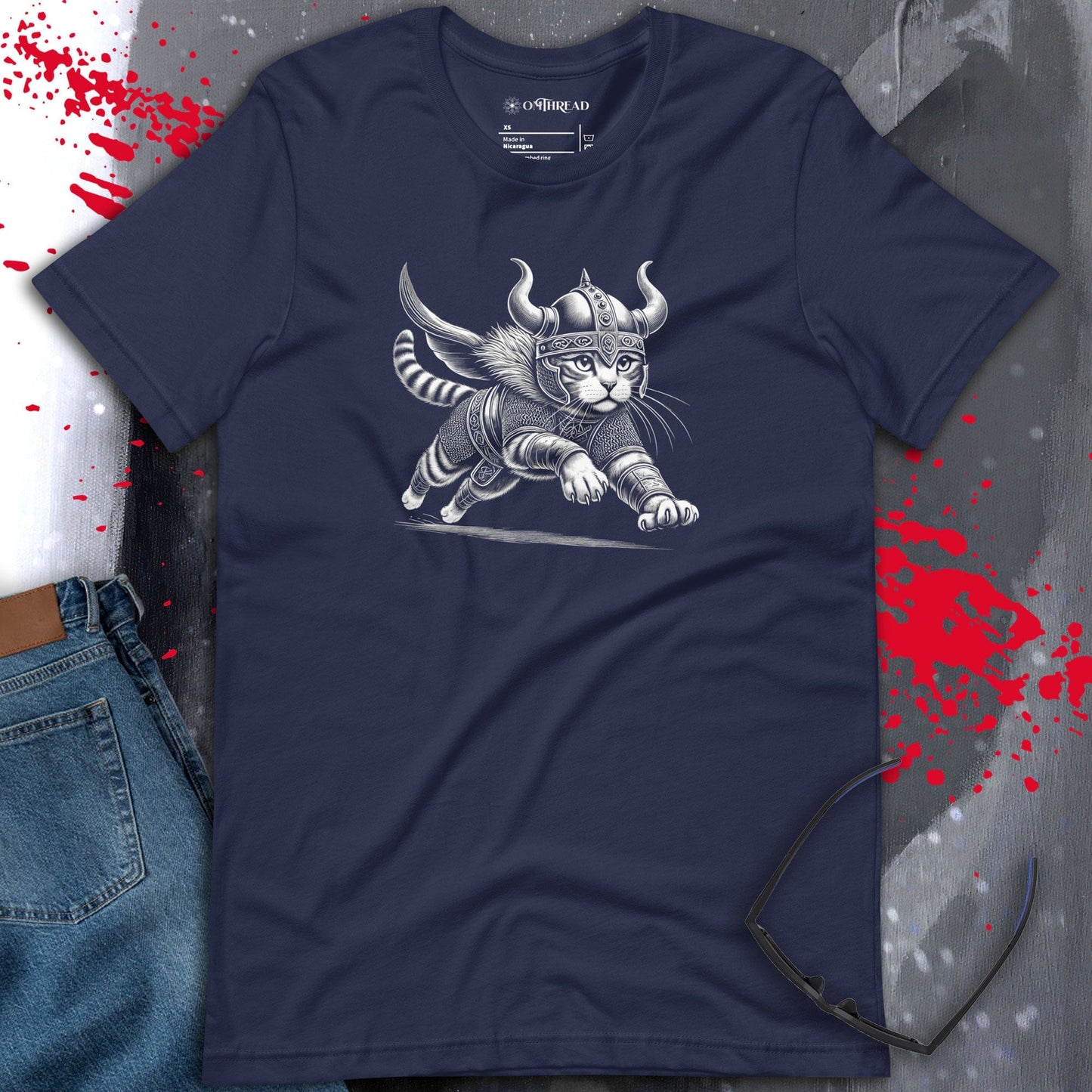 OMThread navy t-shirt featuring a detailed illustration of a Viking cat in mid-leap, wearing intricate Norse armor with a horned helmet. The feline has a fierce expression, gripping a sword with extended claws.