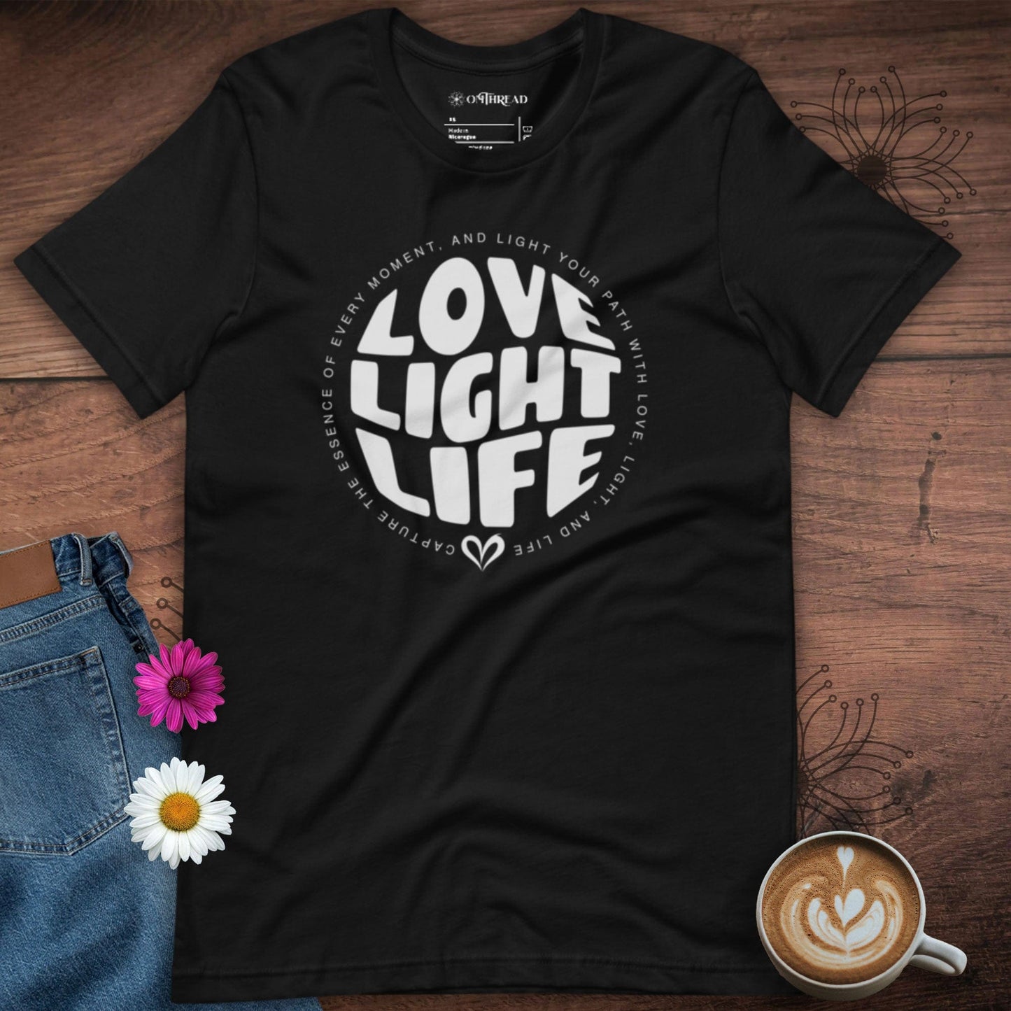OMTHREAD black t-shirt with white circular text design reading "LOVE LIGHT LIFE," surrounded by a positive affirmation.