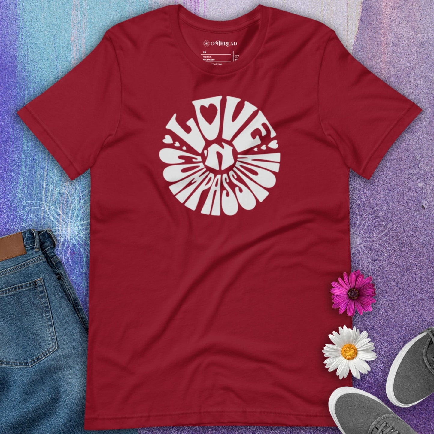 OMTHREAD red t-shirt with bold white "Love 'N Compassion" typography design in a circular layout