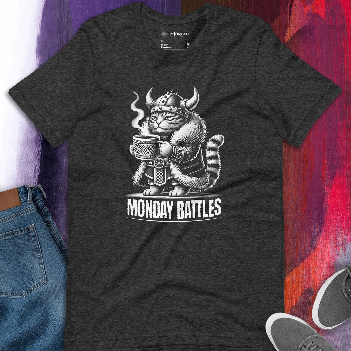 OMTHREAD dark gray Viking cat t-shirt featuring a fierce feline warrior gripping a steaming cup of coffee, wearing a Norse helmet. 'Monday Battles' text included
