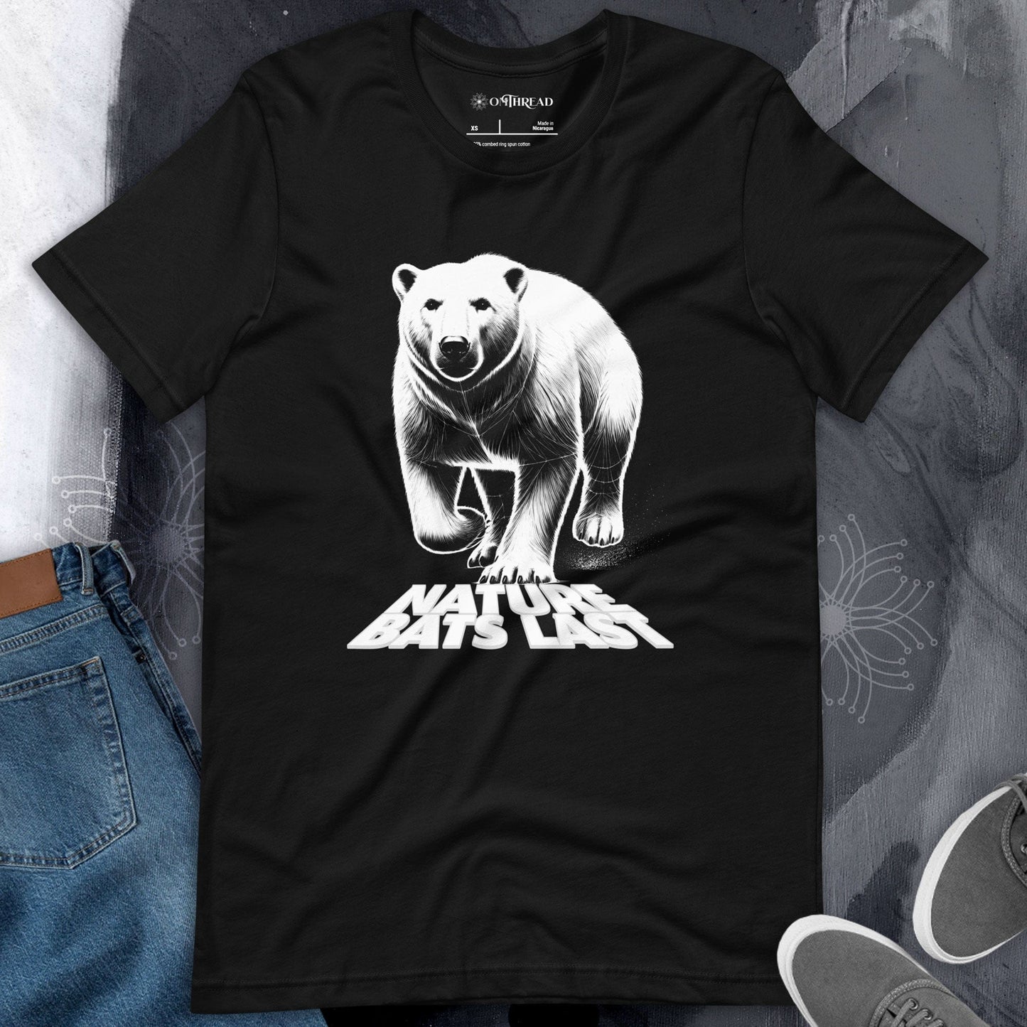 OMTHREAD black t-shirt featuring a detailed white illustration of a polar bear with the bold text "Nature Bats Last" beneath its paws.