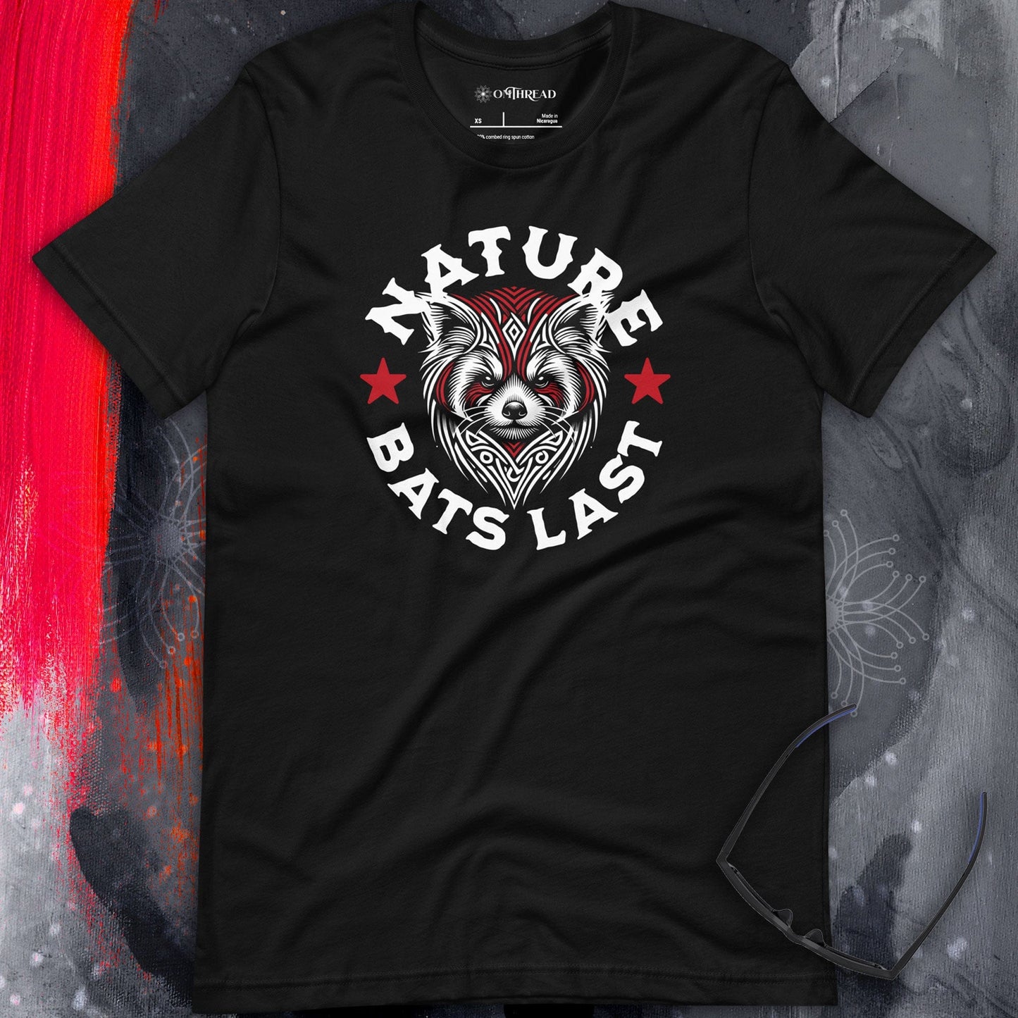 OMThread black t-shirt with a tribal-style red panda illustration and bold "Nature Bats Last" text, featuring red stars on a dark background.