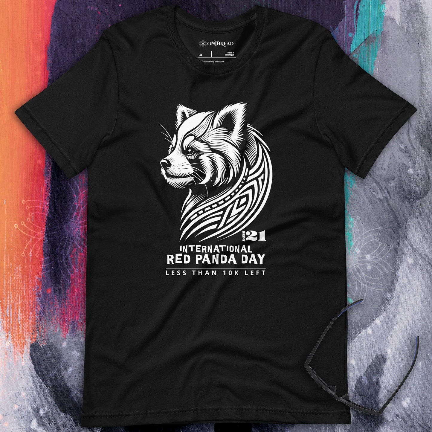 OMThread black t-shirt with white tribal-style red panda illustration and text reading "International Red Panda Day, Less Than 10K Left"
