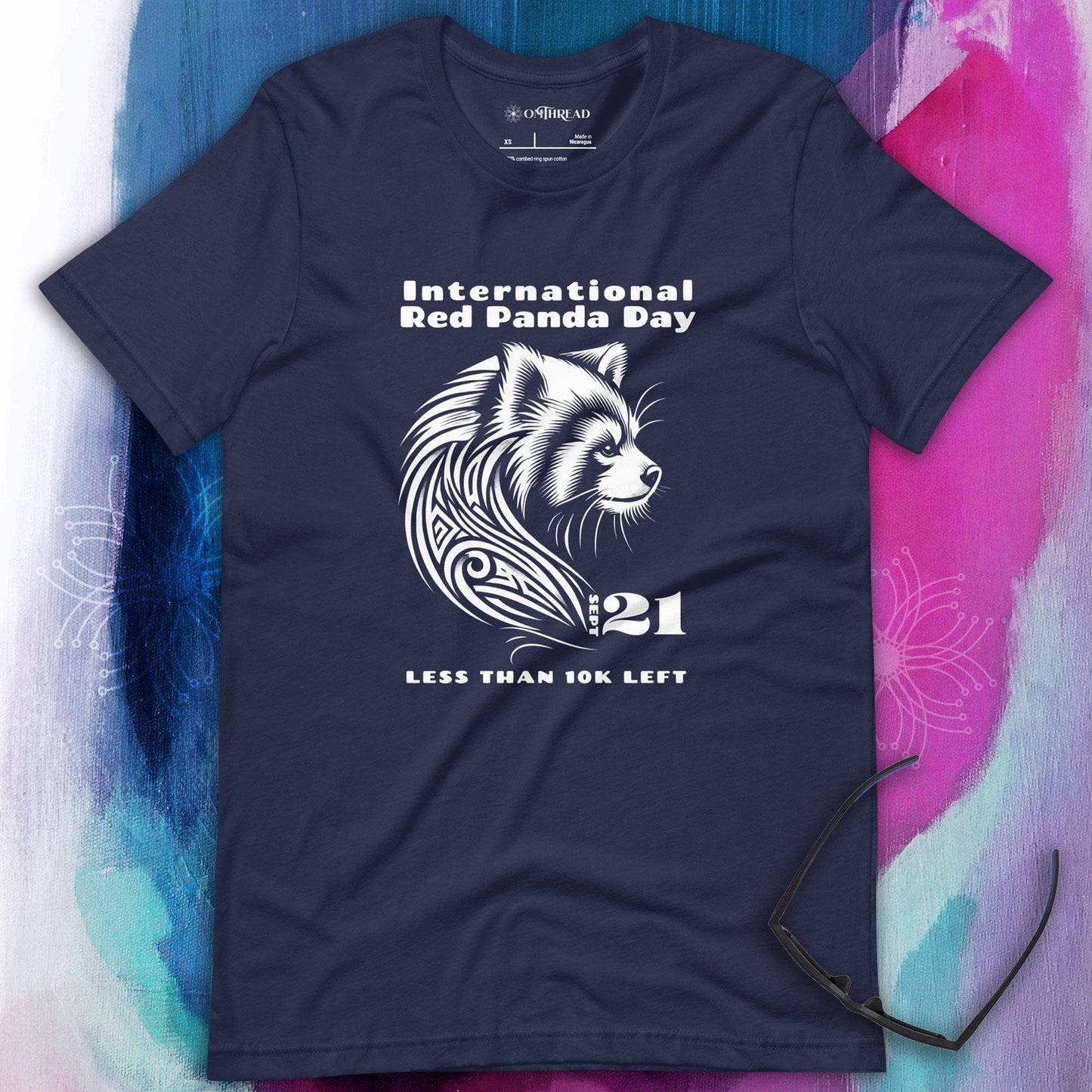 OMThread navy t-shirt featuring a white tribal-style illustration of a red panda with the text "International Red Panda Day 21 Less Than 10K Left"