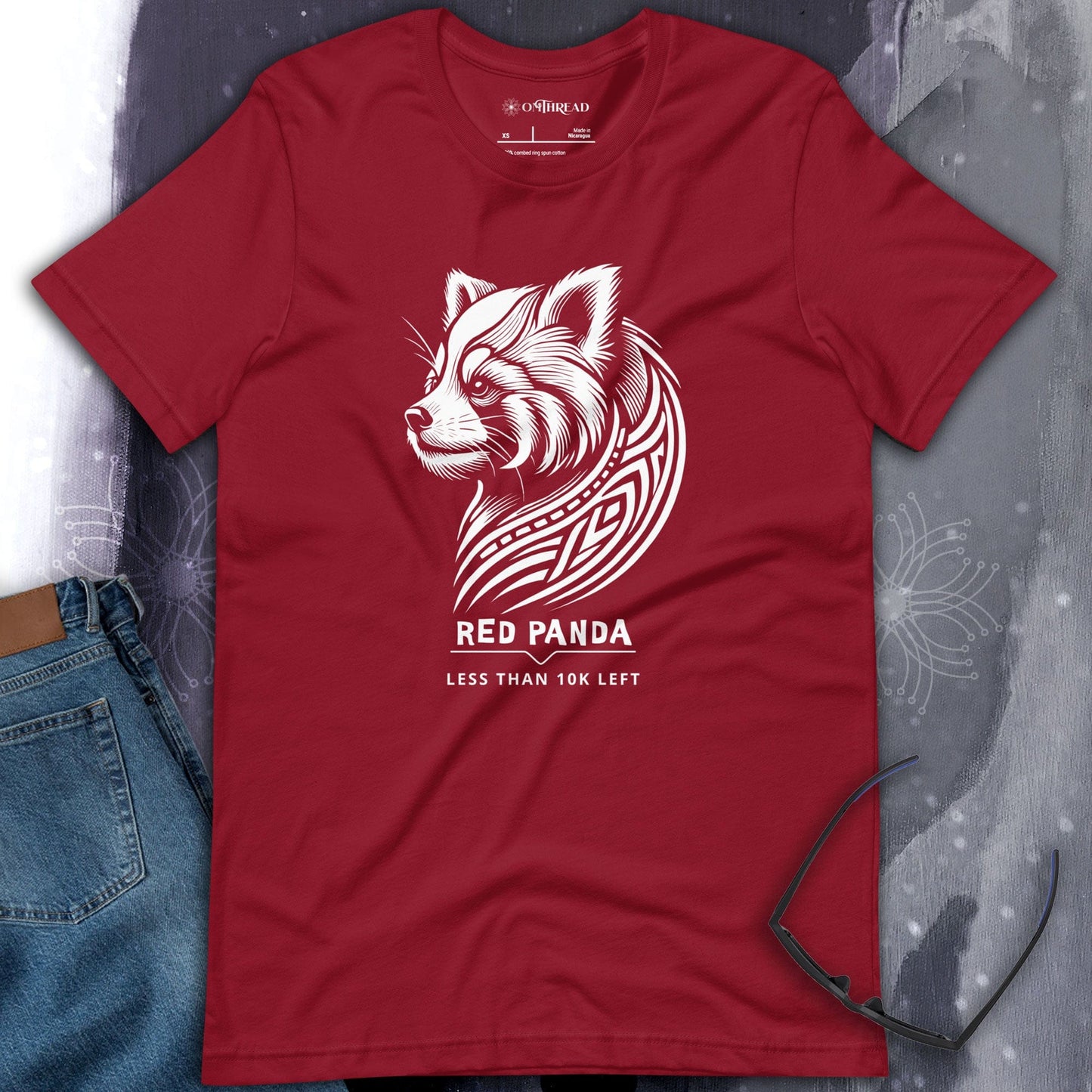 OMThread red cardinal t-shirt featuring a tribal-style red panda illustration with the phrase "Less Than 10K Left," highlighting endangered species awareness.