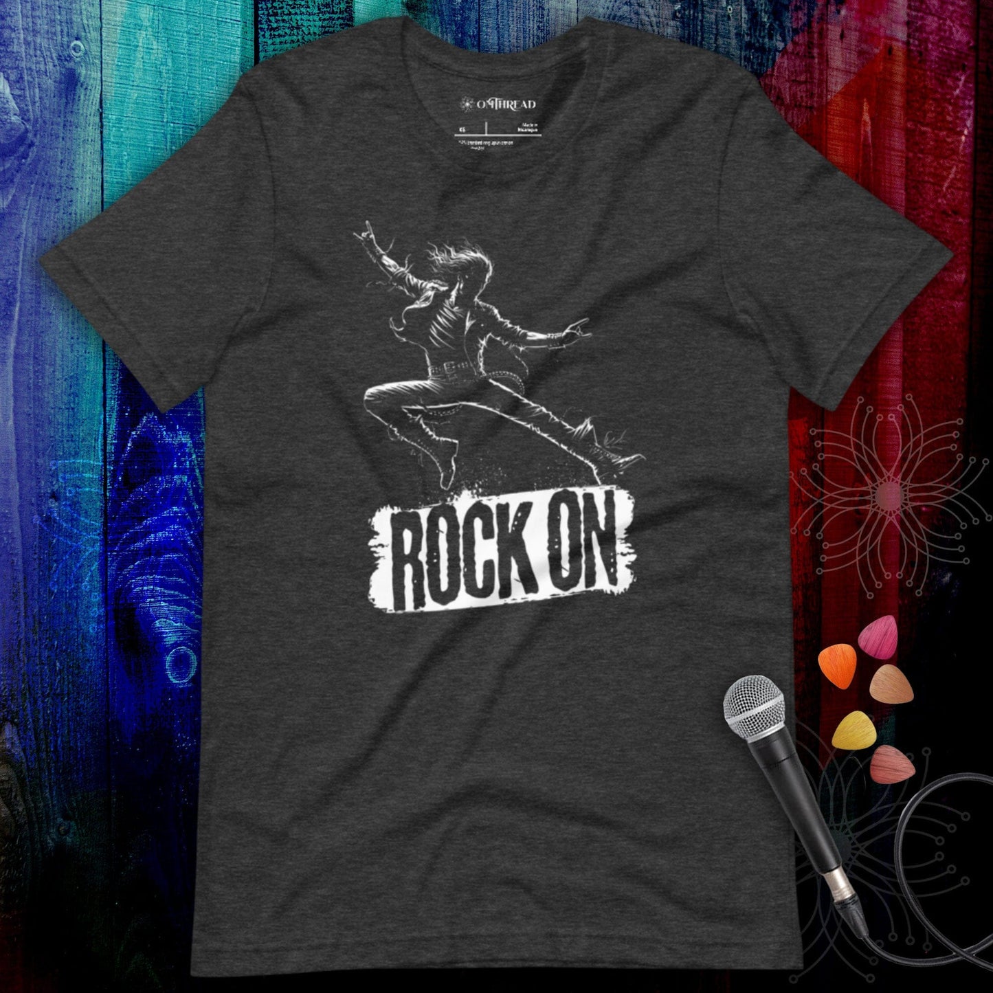 OMTHREAD Rock On Tee, dark gray, featuring a rockstar mid-leap illustration with the text "ROCK ON" in bold.