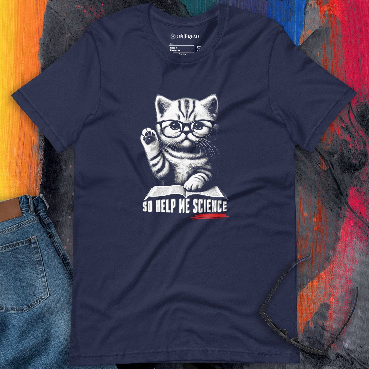 OMTHREAD So Help Me Science navy T-shirt featuring a kitten wearing glasses, raising its paw over an open book with the phrase "So Help Me Science" below