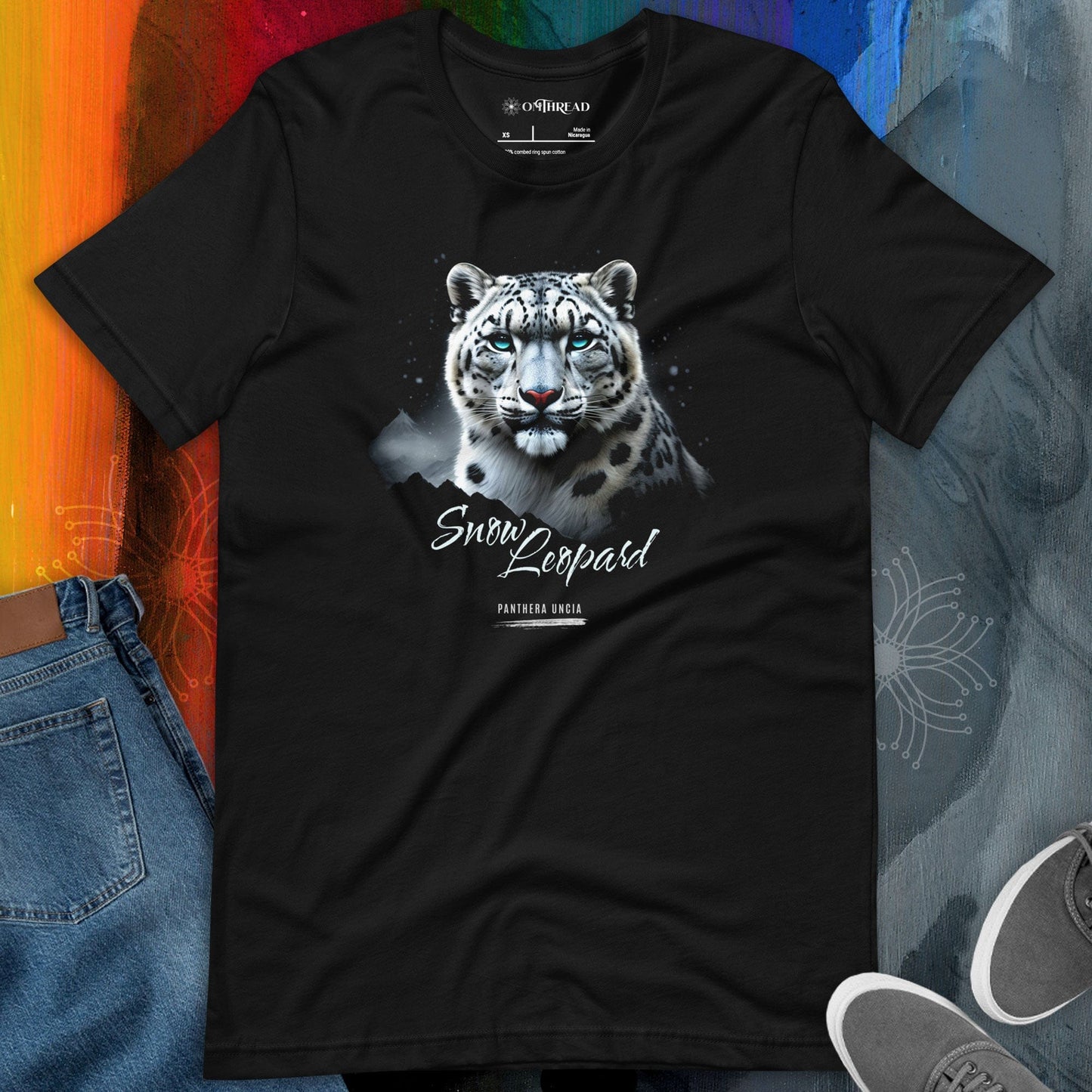 MThread black t-shirt featuring a detailed illustration of a snow leopard with blue eyes, set against a mountainous landscape with a starry night sky. The design includes the words "Snow Leopard" and "Panthera Uncia" in elegant typography.