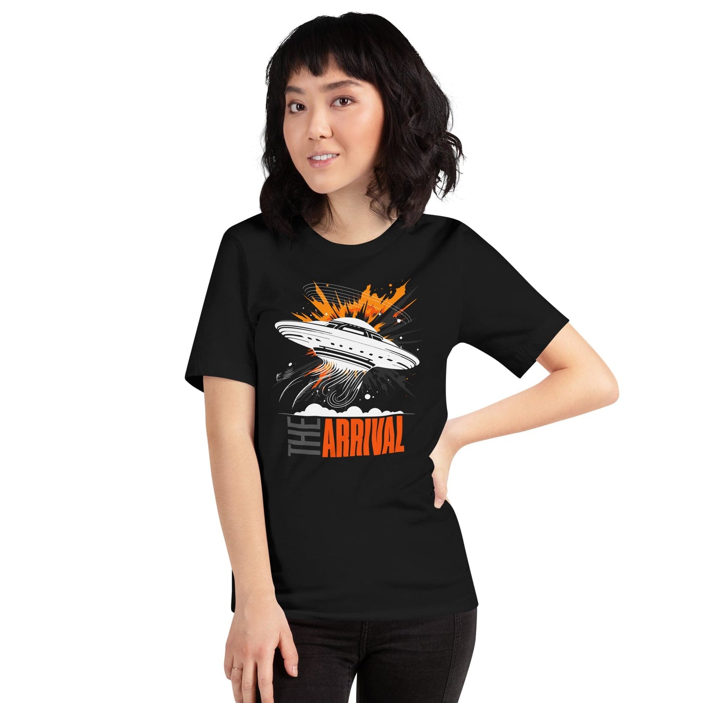 Woman wearing black t-shirt showcasing a bold design of a UFO emitting glowing beams, surrounded by explosive orange accents, clouds, and dynamic motion lines, with the text, THE ARRIVAL in contrasting gray and orange, blending sci-fi and graphic art.