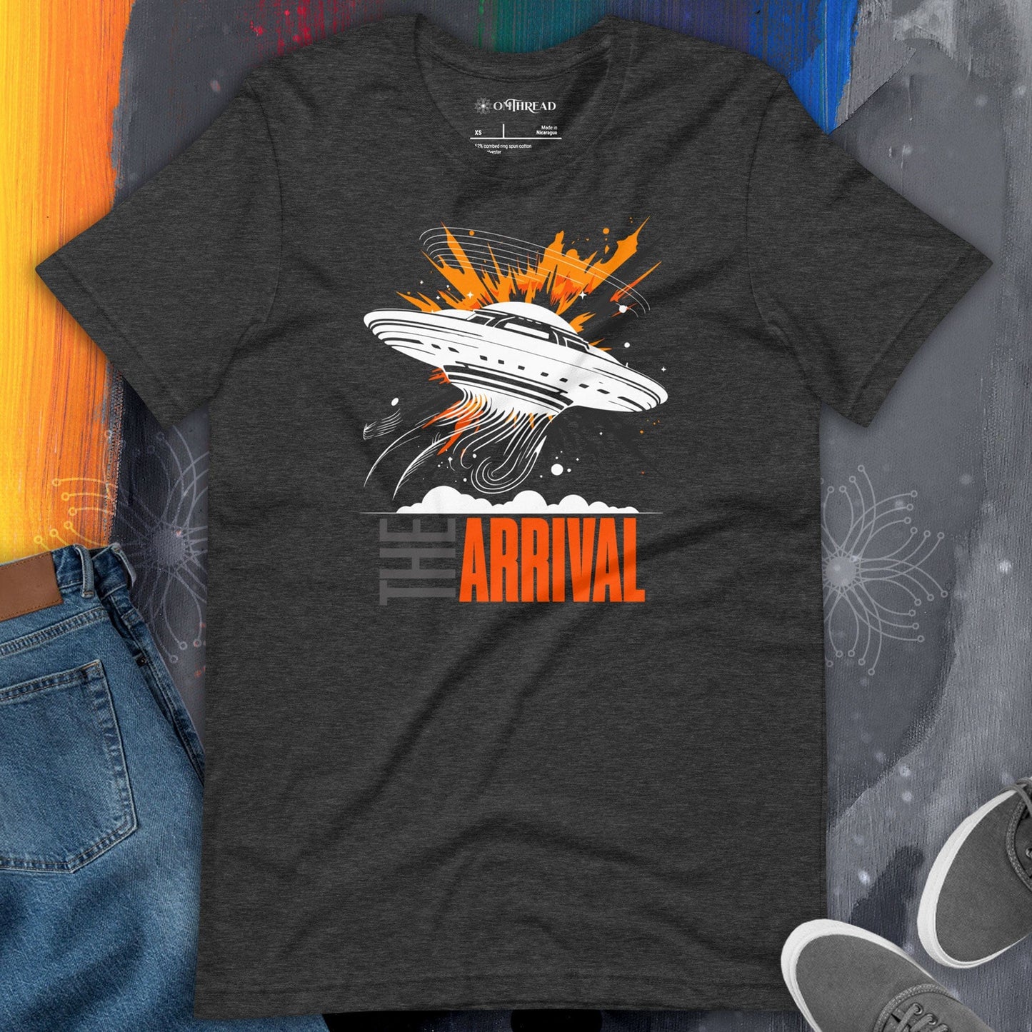 OMThread The Arrival UFO Enthusiast Tee, dark gray, featuring a UFO emitting glowing beams with explosive orange accents and the text "THE ARRIVAL" in contrasting gray and orange.