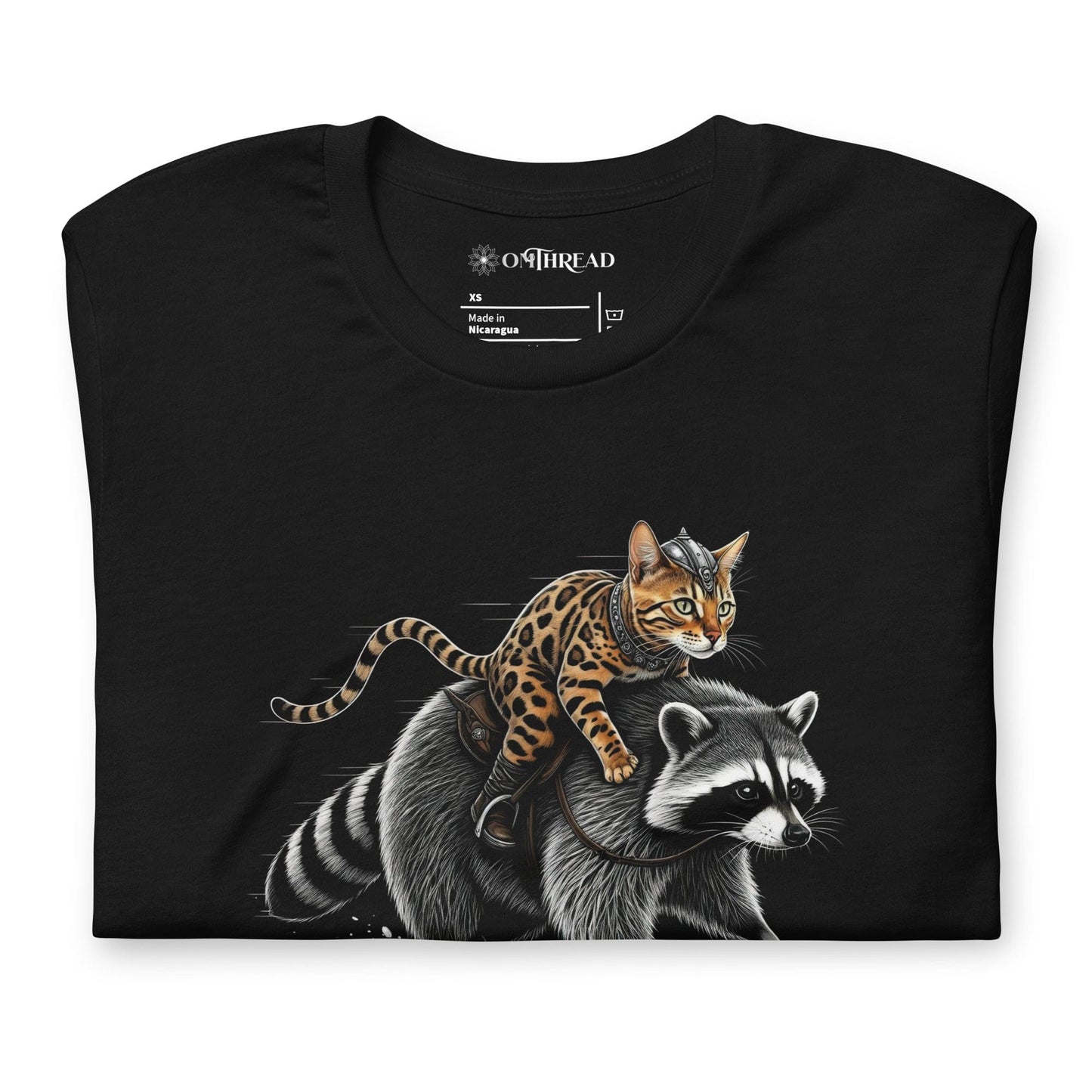 OMTHREAD black t-shirt featuring a Viking warrior cat with Nordic markings riding a determined raccoon. The feline has a fierce expression, gripping the raccoon's fur, while the raccoon strides forward with focus.