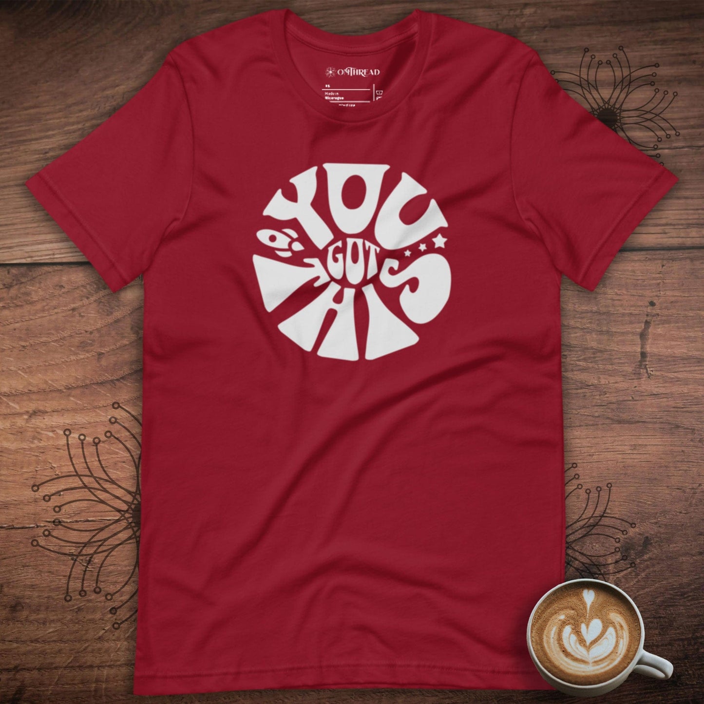 OMTHREAD red t-shirt with bold white text design reading "You Got This" in a circular layout with a playful, motivational style.
