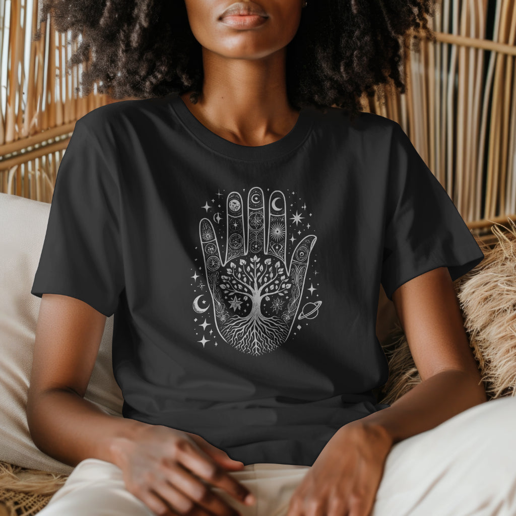 Person wearing a black t-shirt featuring a detailed Hamsa hand design with a tree of life, stars, and celestial elements.