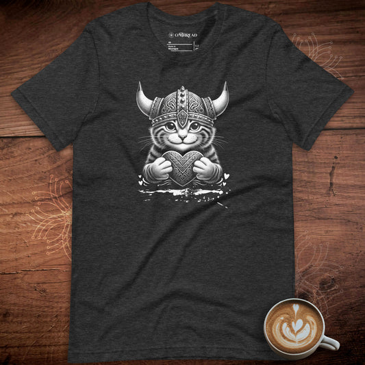 Dark gray t-shirt featuring a Viking cat illustration. The cat wears a detailed Viking helmet with horns and holds an ornate heart, symbolizing love and strength. Small heart accents surround the design. Perfect for cat lovers and Norse mythology fans.