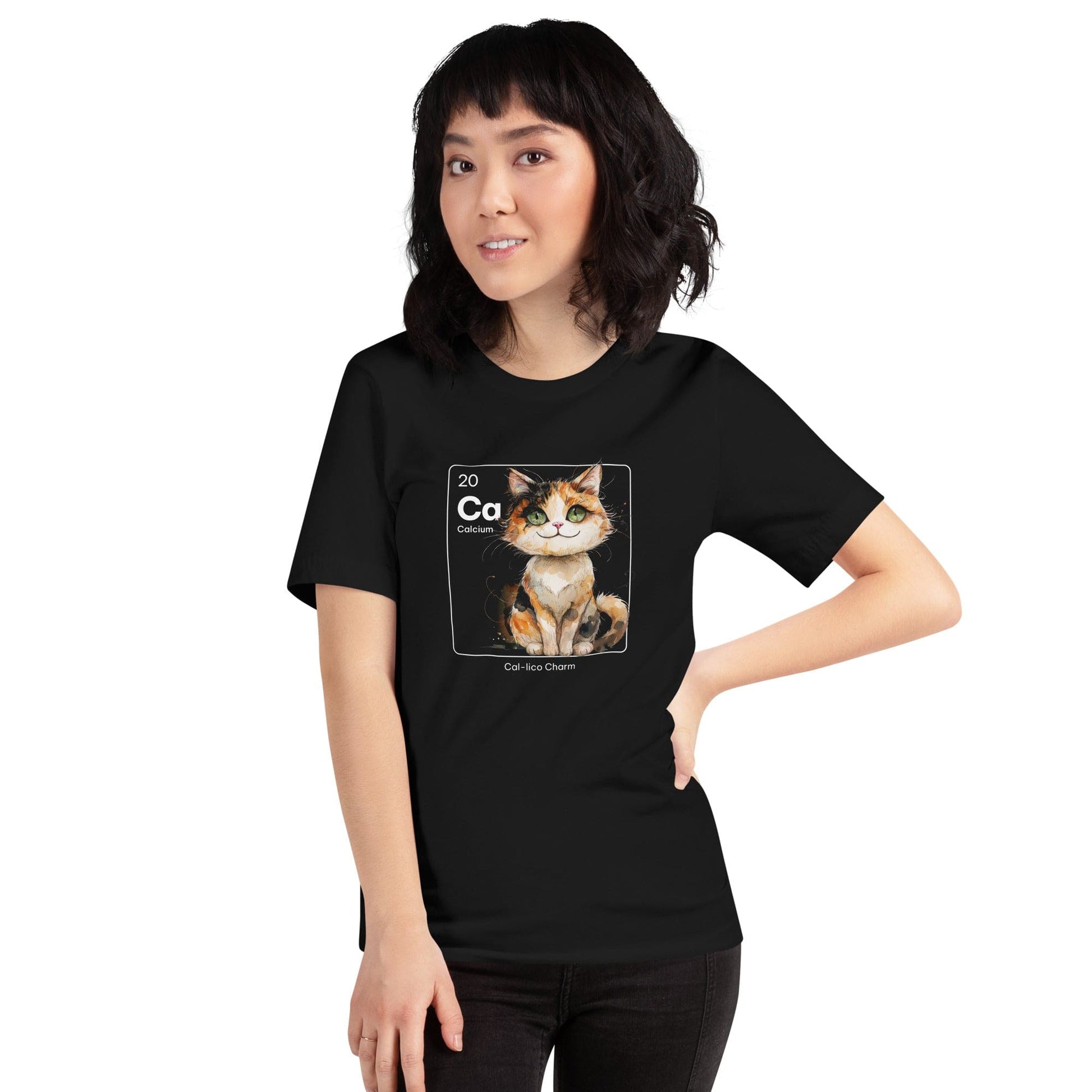 Woman wearing black t-shirt featuring a periodic table-inspired design of a charming, illustrated calico cat within a square labeled 'Ca' for Calcium. Text below reads 'Cal-lico Charm