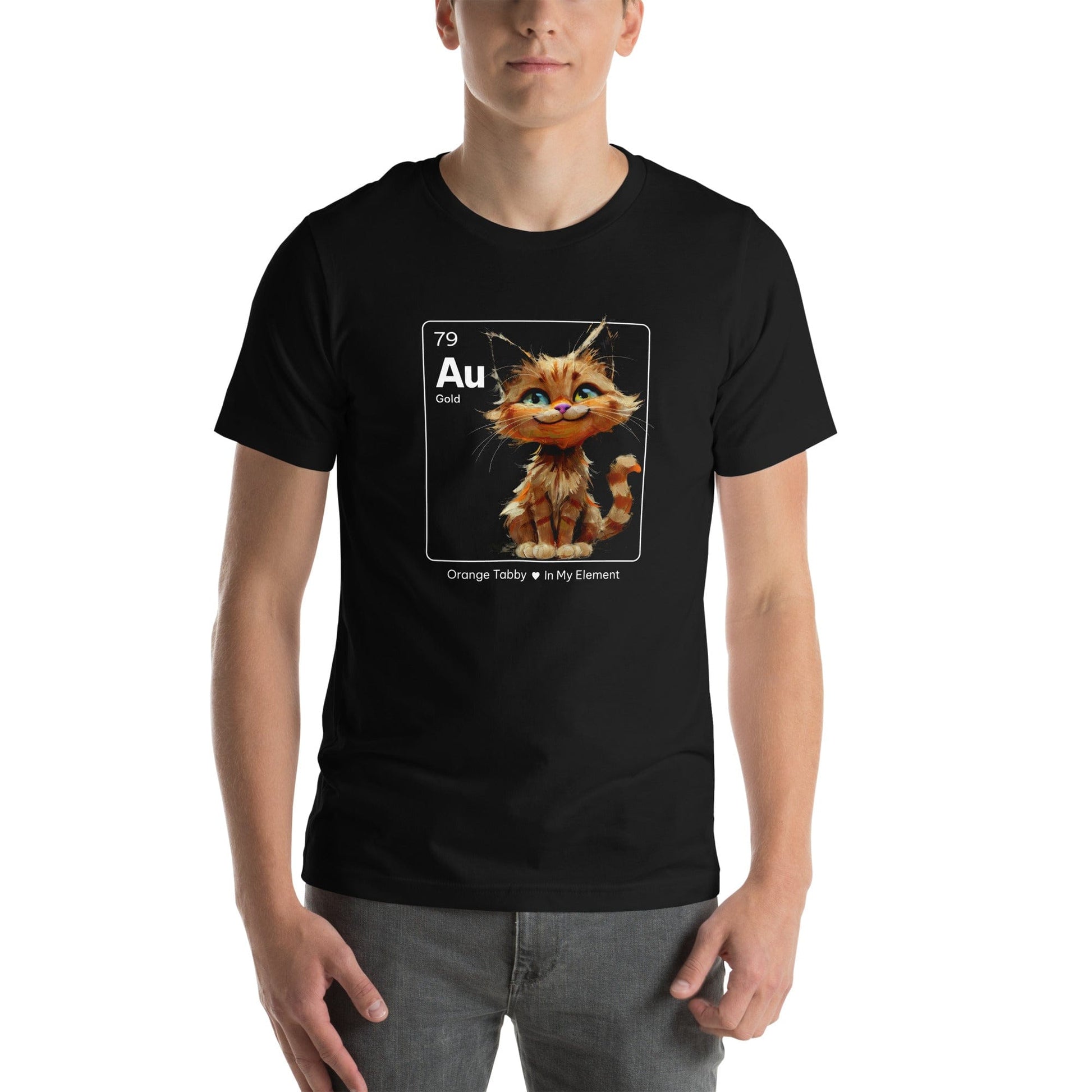 Man wearing a black t-shirt featuring an orange tabby cat sitting cheerfully inside a square design resembling a periodic table element. The square includes 'Au' for gold, the atomic number 79, and the text 'Orange Tabby In My Element' underneath.