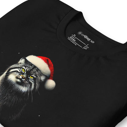 Black t-shirt featuring a Pallas cat wearing a Santa hat, sitting on a snowy rock with a grumpy expression. The text below reads 'GRINCHY PALLAS' in green and red, with the phrase 'My heart grew triple its size' underneath.