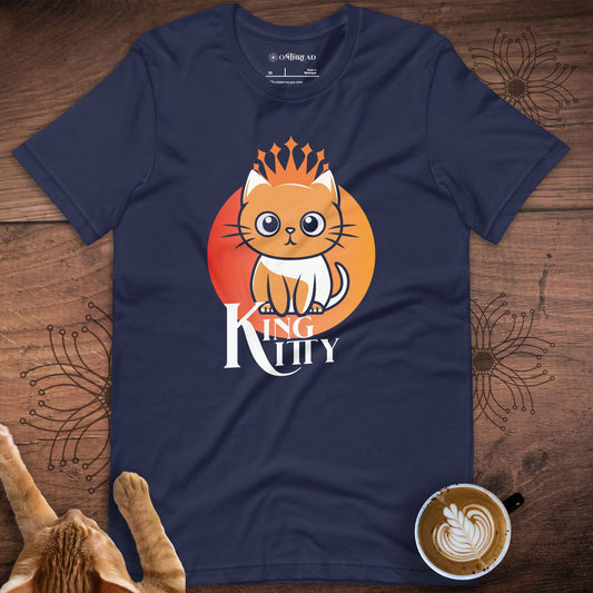 Navy blue t-shirt featuring a cute orange cat illustration sitting in front of an orange gradient circle. The cat wears a stylized crown, and the phrase 'King Kitty' is written below in a bold, royal font.