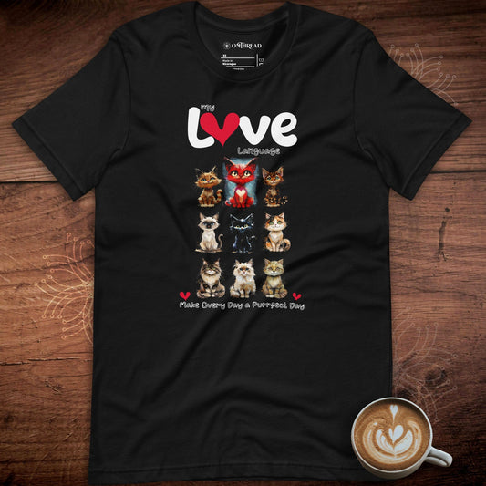 OMTHREAD black t-shirt featuring a grid of illustrated cats with unique expressions. The design includes the phrase "My Love Language" in bold white and red text, with "Make Every Day a Purrfect Day" written below.