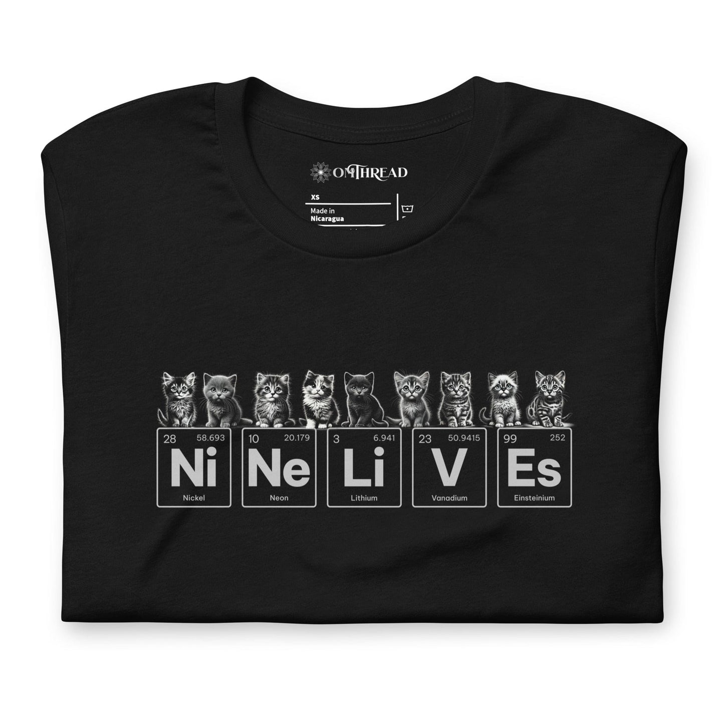 A black t-shirt featuring nine illustrated kittens, each with playful expressions, sitting above periodic table elements that spell 'Ni Ne Li V Es' (Nickel, Neon, Lithium, Vanadium, and Einsteinium), representing 'Nine Lives.