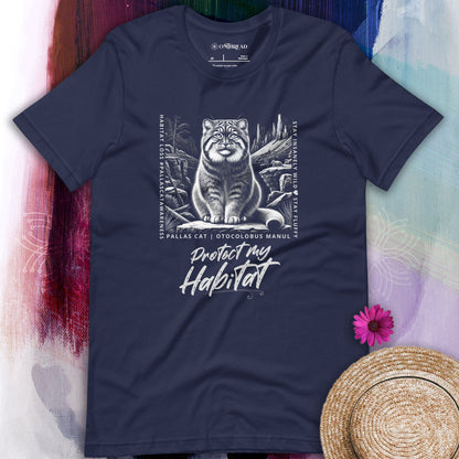 Navy blue t-shirt featuring a detailed black-and-white illustration of a Pallas cat sitting in its natural habitat, surrounded by mountains and rocks. Text reads 'Protect My Habitat' with additional phrases like 'Habitat Loss | Pallas Cat Awareness' and 'Stay Insanely Wild & Stay Fluffy'.