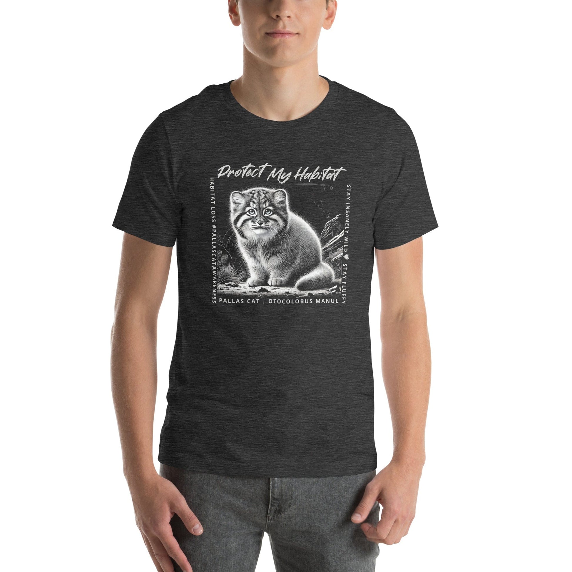 Man wearing Charcoal grey t-shirt featuring a detailed black-and-white illustration of a Pallas Kitten sitting in its habitat. The design includes the phrase 'Protect My Habitat' at the top, with text on the sides reading 'Habitat Loss Pallas Cat Awareness' and 'Stay Insanely Wild & Stay Fluffy'. The bottom features 'Pallas Cat Otocolobus Manul' in clean typography