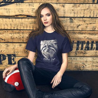 Woman wearing navy t-shirt featuring a close-up, black-and-white illustration of a Pallas kitten's face with striking fur details and intense eyes. Below the image, 'Pallas Cat' is written in elegant white script, followed by 'Otocolobus Manul' in smaller capital letters.