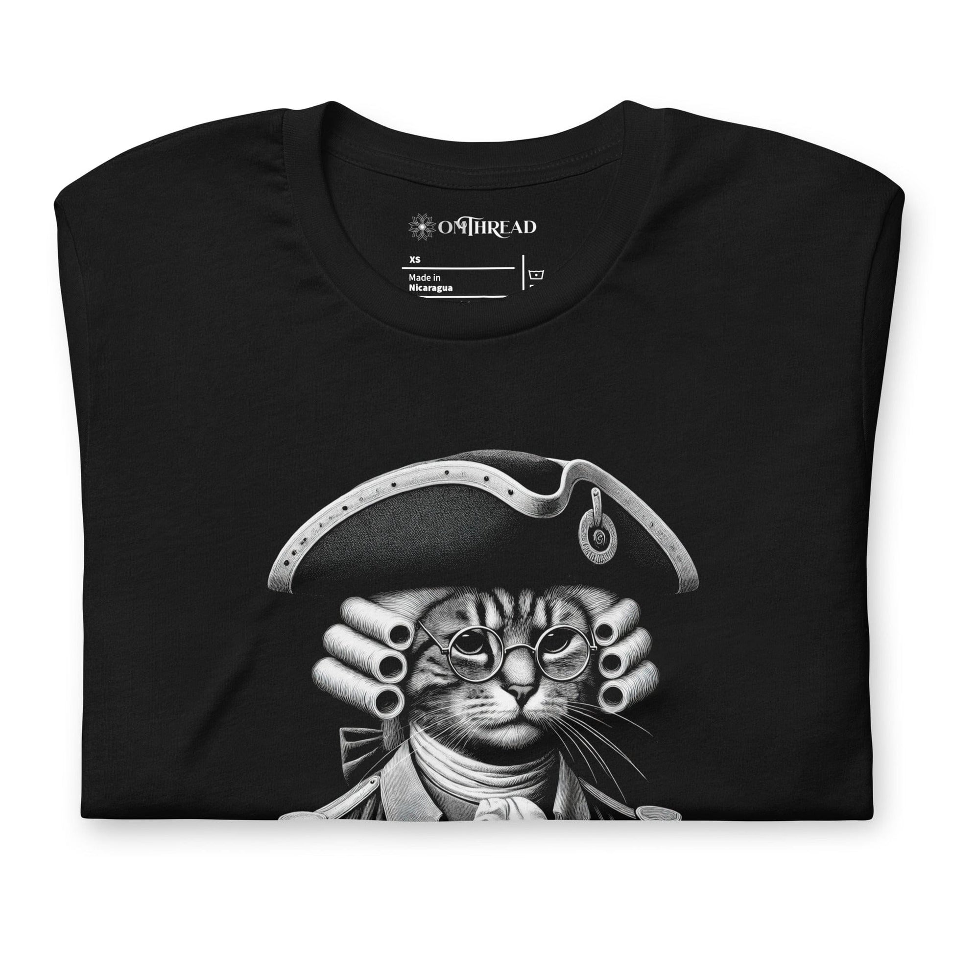 Black t-shirt featuring a humorous design of a cat dressed as a founding father in colonial attire, complete with a tricorne hat and glasses. The text, Pawsuit of Happiness is displayed below in bold, styled with stars and a decorative arch.