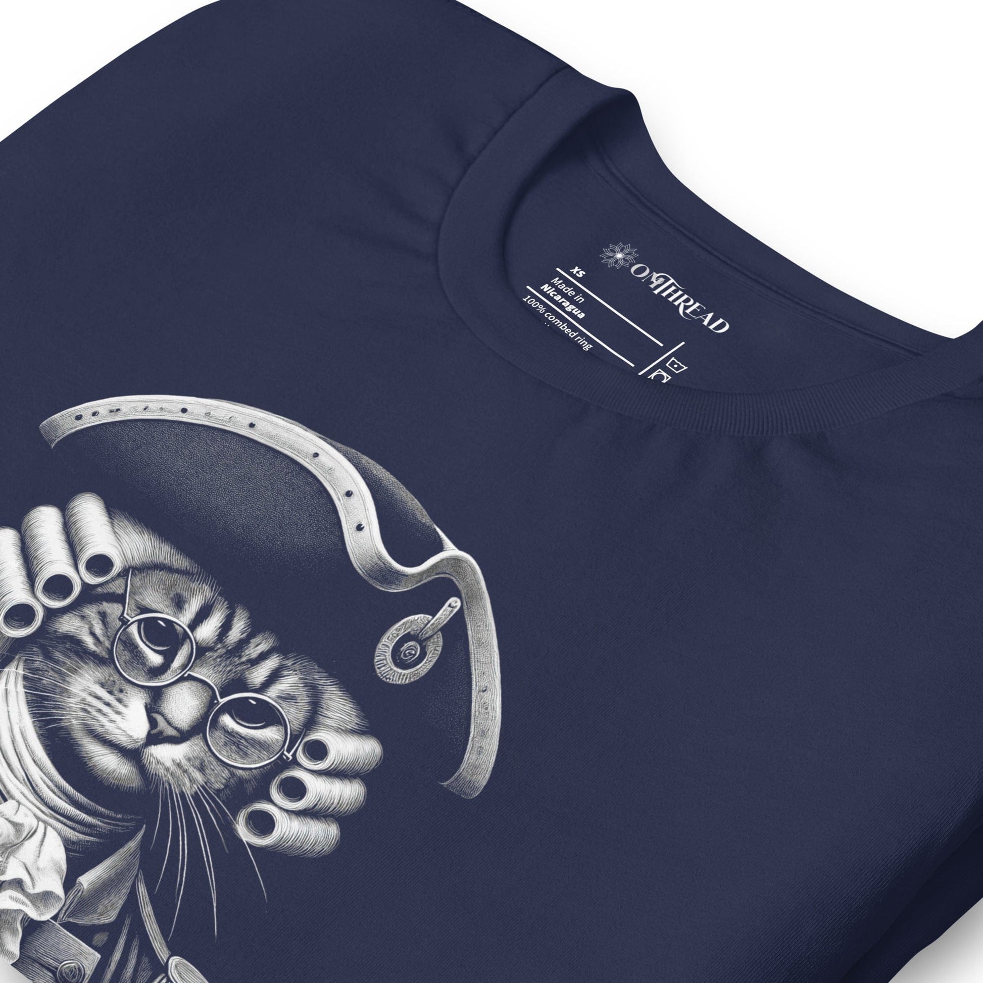 Navy blue t-shirt featuring a humorous design of a cat dressed as a founding father in colonial attire, complete with a tricorne hat and glasses. The text, Pawsuit of Happiness is displayed below in bold, styled with stars and a decorative arch.