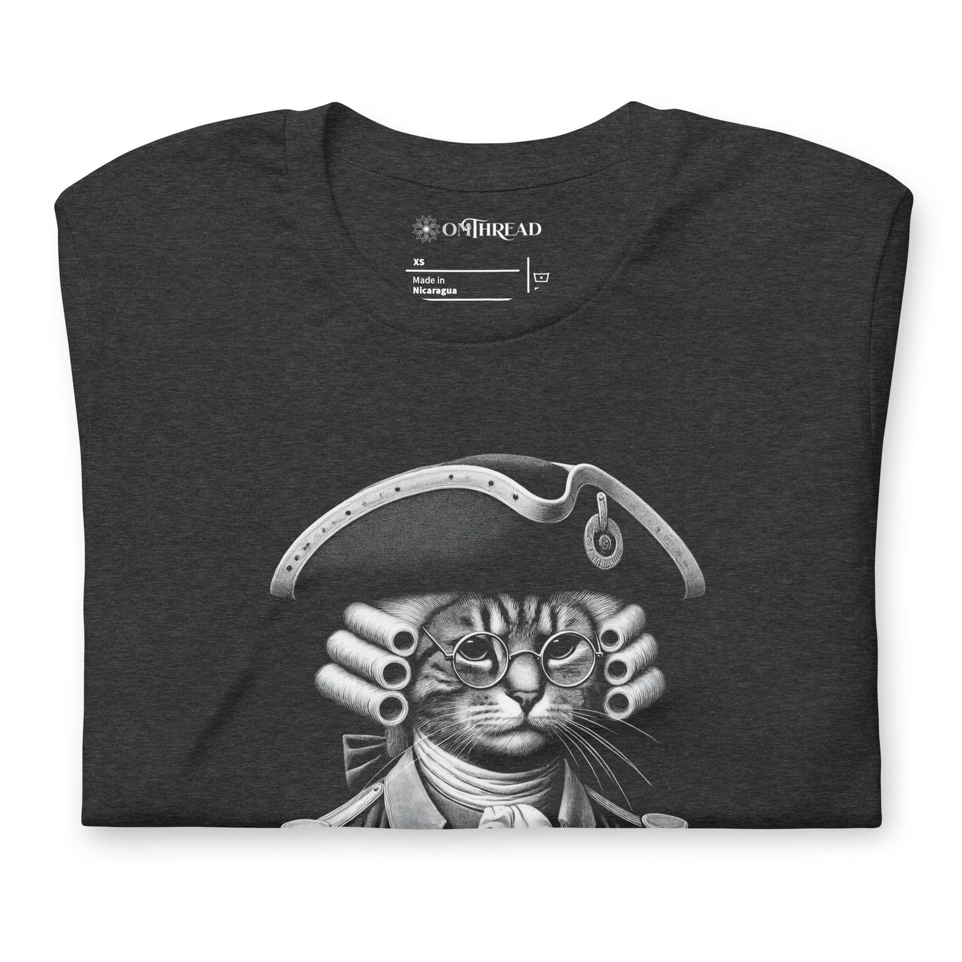 Dark gray t-shirt featuring a humorous design of a cat dressed as a founding father in colonial attire, complete with a tricorne hat and glasses. The text, Pawsuit of Happiness is displayed below in bold, styled with stars and a decorative arch.