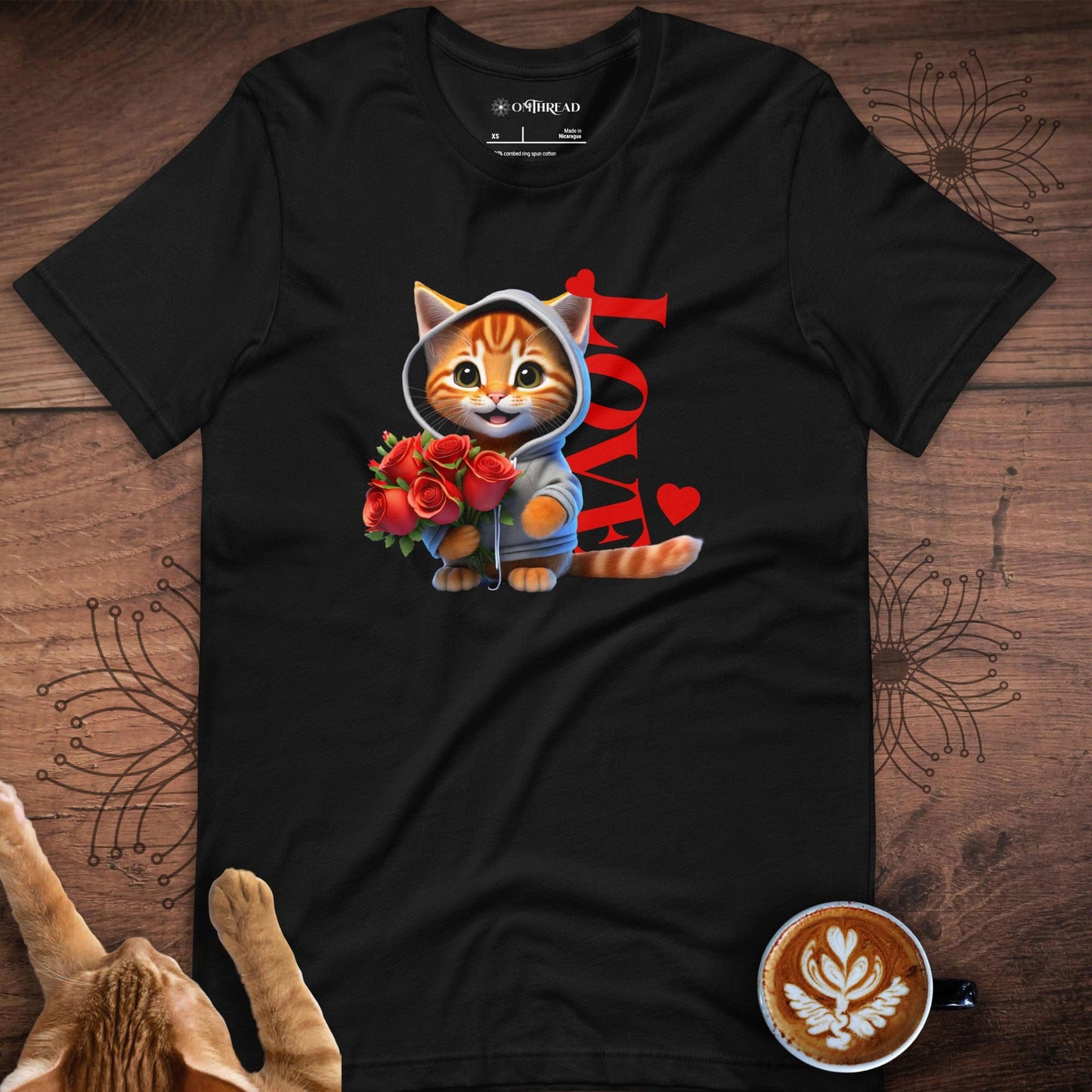 Black t-shirt featuring a cute orange tabby cat wearing a hoodie, holding a bouquet of red roses, with the word 'LOVE' in bold red letters and heart accents behind the cat.