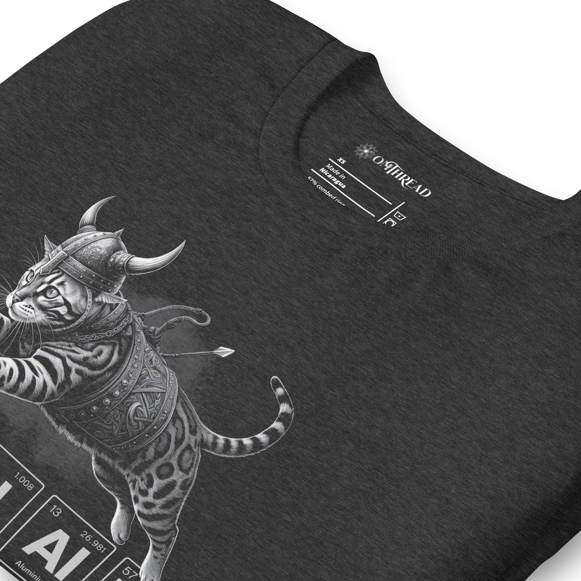 Dark gray t-shirt featuring an illustration of a Viking-style armored cat in mid-leap. Below the cat, the word 'VALHALLA' is spelled out using periodic table elements: Vanadium (V), Aluminum (Al), Hydrogen (H), Aluminum (Al), Aluminum (Al), and Lanthanum (La).