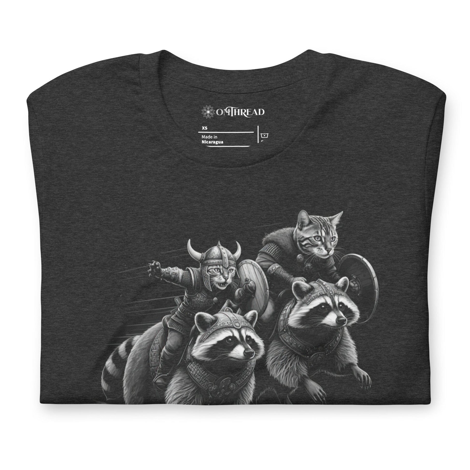 Dark gray t-shirt featuring two Viking cats wearing armor and helmets, riding armored raccoons. One cat holds a sword, and the other carries a shield. The design is detailed with dynamic movement and intricate linework.