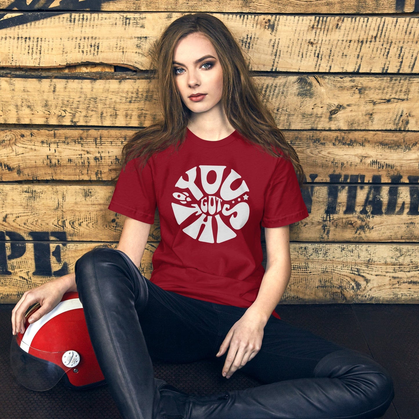 Female model wearing a crimson red t-shirt with the words 'You Got This' in a fun, circular white font. The design includes a small rocket and stars for an extra touch of inspiration.